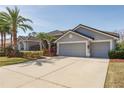Spacious driveway leading to a three-car garage, surrounded by manicured landscaping at 10537 Greensprings Dr, Tampa, FL 33626