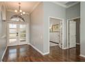 Bright foyer featuring hardwood floors, chandelier, and glass-paneled front door, leading to other rooms in the house at 10537 Greensprings Dr, Tampa, FL 33626