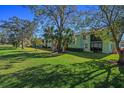 Well-maintained condo building surrounded by lush greenery and mature trees on a sunny day at 128 Nancy Dr # 128, Oldsmar, FL 34677
