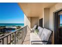 Charming balcony featuring outdoor seating with views of the turquoise ocean, palm trees, and community pool at 1480 Gulf Blvd # 410, Clearwater Beach, FL 33767