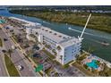 Aerial view of Portside Condominiums featuring waterfront location, pool, and tennis court at 18325 Gulf Blvd # 509, Redington Shores, FL 33708