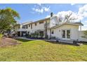 Spacious backyard with a well-maintained lawn, a patio area, and mature trees providing shade at 19 Sandpiper Rd, Tampa, FL 33609