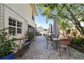 An inviting brick patio featuring outdoor seating, lush greenery, and a serene backyard view, perfect for relaxation at 19 Sandpiper Rd, Tampa, FL 33609