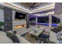Covered outdoor living space with fireplace, TV, plush seating, pool and waterfront views at 201 Punta Vista Dr, St Pete Beach, FL 33706