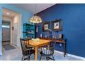 Cozy dining area with bright blue accent wall, wooden table, and pendant light at 32960 Regent Canal St, Wesley Chapel, FL 33545