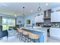 Open-concept kitchen featuring a spacious island with bar seating and modern appliances at 32960 Regent Canal St, Wesley Chapel, FL 33545