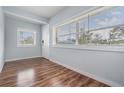 Inviting living room features stylish wood floors, natural light from large windows, and a fresh neutral paint palette at 3620 E Shadowlawn Ave, Tampa, FL 33610