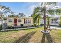 A charming home with a mature palm tree and landscaped garden beds, set on a well-maintained lawn at 36936 Kay Ave, Zephyrhills, FL 33542