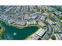 Aerial view showcases the community layout with lush landscaping and a serene lake at 4355 Tahitian Gardens Cir # D, Holiday, FL 34691