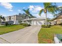 Inviting single-story home features a long driveway and tropical landscaping, creating a welcoming entrance at 45 Gulfwinds W Dr, Palm Harbor, FL 34683