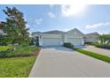 Inviting home exterior featuring a spacious two-car garage, well-manicured landscaping, and a long concrete driveway at 4524 Deep Creek Ter, Parrish, FL 34219