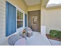 Charming covered front porch with seating and blue shuttered window, creating a welcoming entrance at 4524 Deep Creek Ter, Parrish, FL 34219