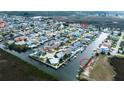 Aerial view of a canal community showcasing waterfront homes with docks and waterway access surrounded by nature at 7034 Southwind Dr, Hudson, FL 34667