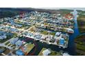 Aerial view of a waterfront community featuring homes along canals with boat docks, surrounded by lush greenery at 7034 Southwind Dr, Hudson, FL 34667