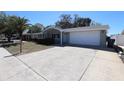 Well-maintained home with an attached garage and large driveway and a vibrant green lawn at 7144 Fairfax Dr, Port Richey, FL 34668