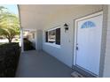 Welcoming front porch featuring a brick facade, classic entry door, and a shaded sitting area at 7144 Fairfax Dr, Port Richey, FL 34668
