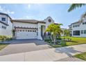 Charming home with a paved driveway, well-kept lawn, and a two-car garage beneath a bright sky at 1009 Seagrape Dr, Ruskin, FL 33570