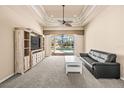 Cozy living room with a view of the pool, a ceiling fan, and a plush carpet at 10364 Locker Dr, Spring Hill, FL 34608