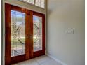 Elegant wooden double front doors with decorative glass panels create a warm and inviting entrance at 10614 Chambers Dr, Tampa, FL 33626