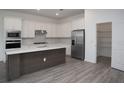 Well-equipped kitchen boasts stainless steel appliances, white cabinetry and convenient walk-in pantry at 14184 Hammock Crest Way, Riverview, FL 33569