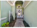 Inviting front porch featuring a decorative wreath on the front door and a charming bench at 1514 River Ct, Tarpon Springs, FL 34689