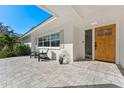 Inviting front porch area with a paved surface, seating, and a view of the front door and windows at 1664 Sharon Way, Clearwater, FL 33764
