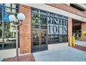 Exterior shot of the Minute Lofts building entrance with brick facade, front door, and reflective windows at 175 2Nd S St # P03, St Petersburg, FL 33701