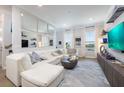 Bright living room featuring modern decor, a white leather sectional, and open windows at 19915 Gulf Blvd # 704, Indian Shores, FL 33785