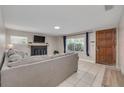 Cozy living room with a decorative fireplace, comfortable gray sofa, and plenty of natural light at 305 6Th Sw Ave, Largo, FL 33770