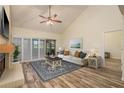 Bright living room featuring vaulted ceiling, fireplace, sliding doors, and elegant decor at 3130 Eagles Landing W Cir, Clearwater, FL 33761
