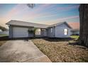 A charming single-story home with a well-maintained lawn and a beautiful, colorful sky at dusk at 3426 Monte Rio St, New Port Richey, FL 34655