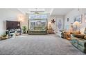 Bright living room featuring plush carpeting, high tray ceilings, and comfortable seating at 37508 Gill Ave, Zephyrhills, FL 33541