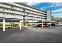Exterior view of the condo building featuring covered resident parking and meticulous landscaping at 4240 Ironwood Cir # 404, Bradenton, FL 34209