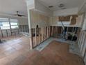 View of a living room awaiting renovation, showing the walls stripped and a ceiling fan at 4525 29Th S Ave, Gulfport, FL 33711