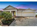 Inviting home with an extended driveway, three-car garage, and elegant exterior lighting at 618 Manns Harbor Dr, Apollo Beach, FL 33572