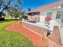 Cozy home exterior with well-kept lawn and decorative flower bed at 6504 Brentwood Dr, Zephyrhills, FL 33542