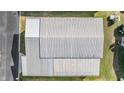 Aerial view of a house featuring a light grey metal roof with a car parked outside at 7133 El Matador St, Zephyrhills, FL 33541