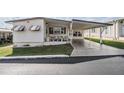 A single Gathering home with an attached carport, landscaped yard, and outdoor seating area at 7133 El Matador St, Zephyrhills, FL 33541