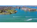 Aerial view of the beautiful community surrounded by the turquoise bay and boats cruising on the open water at 10355 Paradise Blvd # 909, Treasure Island, FL 33706