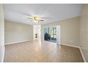 Spacious living room with tile flooring, ceiling fan and sliding glass doors leading to an outdoor area at 11407 3Rd N St # 1, St Petersburg, FL 33716