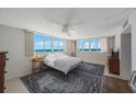 Bright bedroom with large windows offering panoramic ocean views and a ceiling fan at 17920 Gulf Blvd # 1103, Redington Shores, FL 33708
