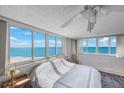 Bright bedroom with large windows offering panoramic ocean views and a ceiling fan at 17920 Gulf Blvd # 1103, Redington Shores, FL 33708
