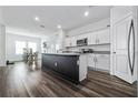 Open kitchen features an island, granite countertops, and stainless steel appliances, adjacent to a dining area at 2375 Harris Hawk Ave, Ruskin, FL 33570