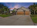 This one-story house has a three-car garage and a well-manicured front lawn at 2981 Northfield Dr, Tarpon Springs, FL 34688