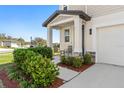 Cozy front porch with seating and well-manicured landscaping at 3224 Fresno Pl, Zephyrhills, FL 33541