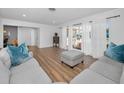 Bright living room featuring new wood flooring, light gray sofas, and large windows at 4191 39Th S St, St Petersburg, FL 33711