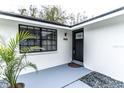 Exterior view of the front door and entry with modern details and minimalist landscaping at 4222 Autumn Leaves Dr, Tampa, FL 33624