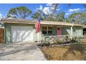 Inviting home with a freshly painted light green facade, a manicured front garden, and an American flag at 4407 Parnell Dr, Sarasota, FL 34232