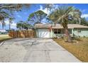 Well-maintained home with a lush lawn, white garage door, and a wooden privacy fence for added security at 4407 Parnell Dr, Sarasota, FL 34232