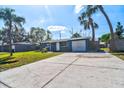 Charming single-story home with blue exterior, driveway, and lush palm trees at 5600 Bay Ne St, St Petersburg, FL 33703
